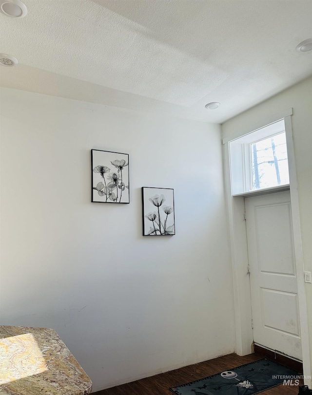 bedroom featuring dark hardwood / wood-style flooring and a textured ceiling