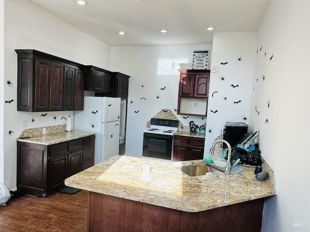 kitchen featuring white appliances, sink, dark hardwood / wood-style floors, dark brown cabinetry, and kitchen peninsula