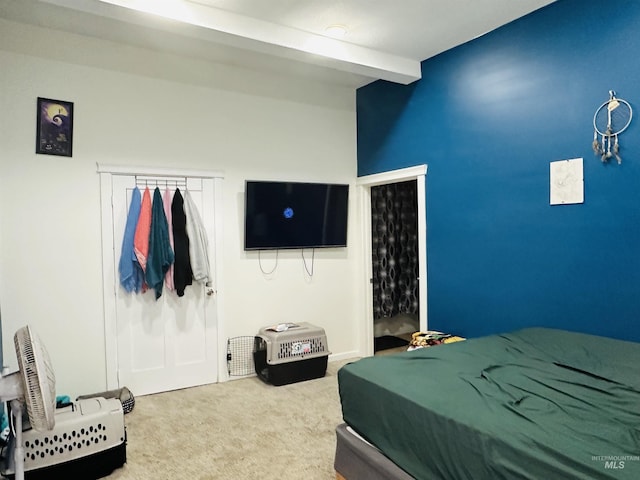 bedroom featuring beamed ceiling and carpet flooring