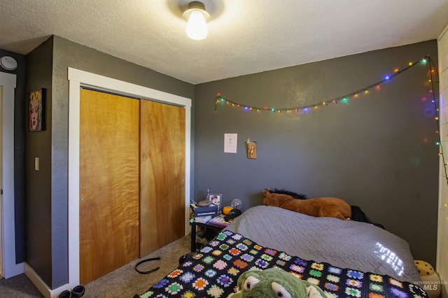 carpeted bedroom with a textured ceiling and a closet
