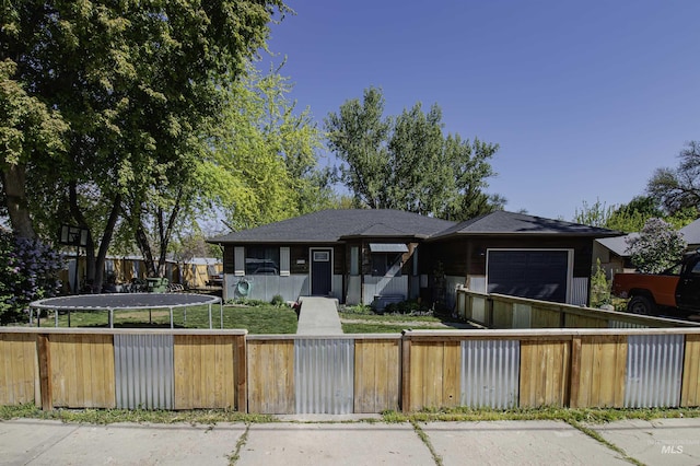 bungalow-style home with a garage and a fenced front yard