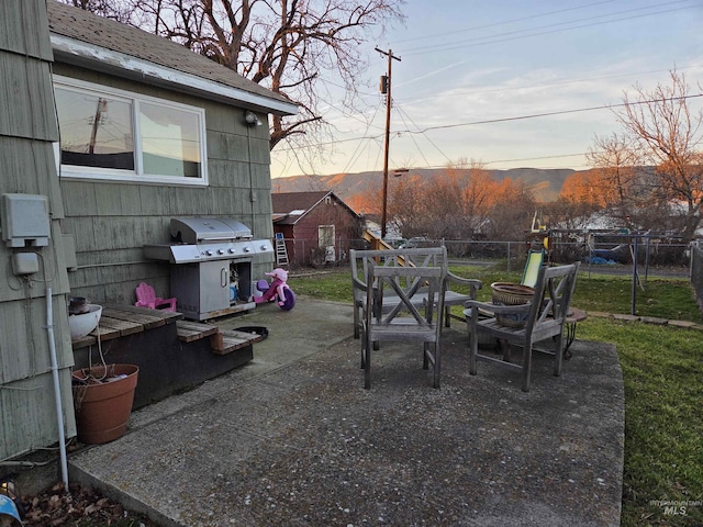 view of yard featuring outdoor dining space, a mountain view, fence, and a patio