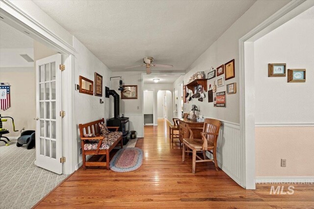7425 Robinson Rd, Kuna, ID 83634 - hall with arched walkways, light wood finished floors, and a wainscoted wall