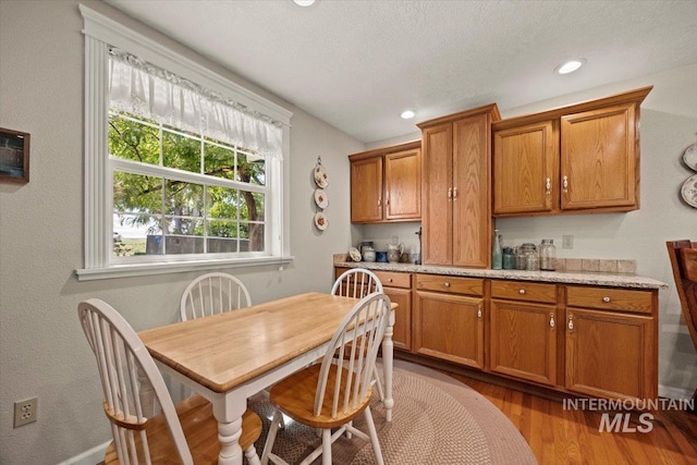 7425 Robinson Rd, Kuna, ID 83634 - kitchen with brown cabinetry, wood finished floors, light countertops, and recessed lighting