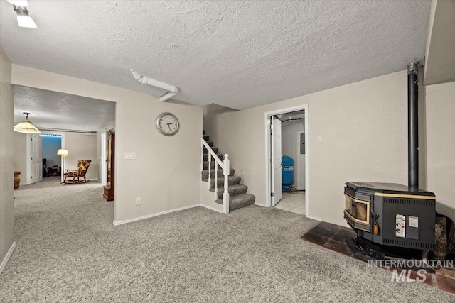 7425 Robinson Rd, Kuna, ID 83634 - carpeted living room featuring a wood stove, stairs, and a textured ceiling