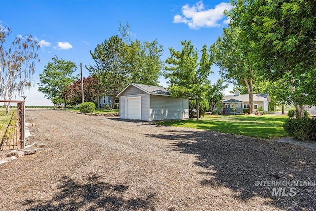 7425 Robinson Rd, Kuna, ID 83634 - view of green lawn featuring a detached garage, an outdoor structure, and driveway