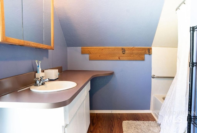 304 6th Ave, Lewiston, ID 83501 - bathroom featuring vanity, vaulted ceiling, wood finished floors, a tub, and a shower with shower curtain