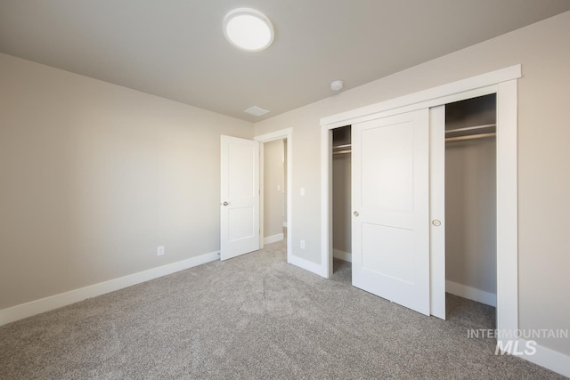 unfurnished bedroom featuring carpet, a closet, and baseboards