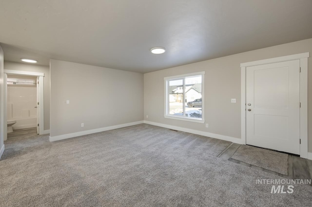 unfurnished room featuring light carpet and baseboards