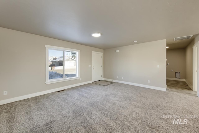 empty room featuring light carpet, visible vents, and baseboards