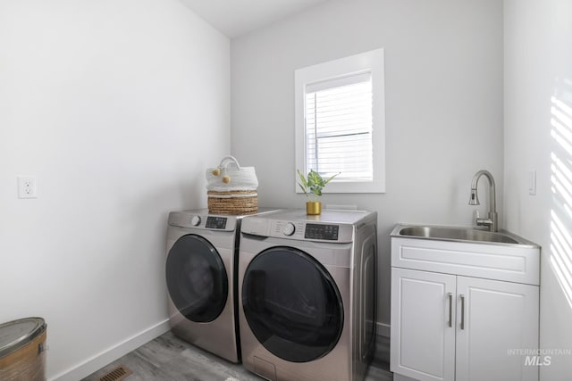 922 Victory Dr, Gooding, ID 83330 - laundry area featuring baseboards, cabinet space, separate washer and dryer, a sink, and light wood-style floors
