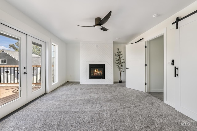 922 Victory Dr, Gooding, ID 83330 - unfurnished living room with a ceiling fan, a barn door, a large fireplace, french doors, and carpet flooring