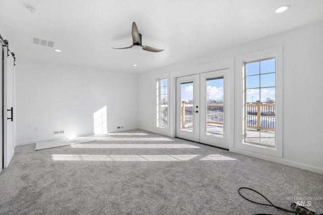 922 Victory Dr, Gooding, ID 83330 - empty room featuring visible vents, carpet flooring, a ceiling fan, and a healthy amount of sunlight