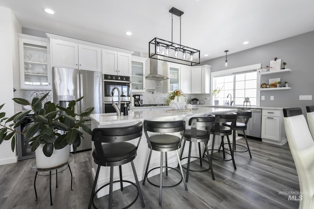 922 Victory Dr, Gooding, ID 83330 - kitchen featuring decorative backsplash, wall chimney range hood, white cabinets, and appliances with stainless steel finishes