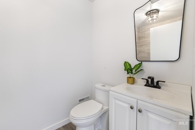 922 Victory Dr, Gooding, ID 83330 - half bathroom featuring visible vents, baseboards, toilet, and vanity