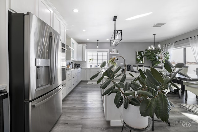 922 Victory Dr, Gooding, ID 83330 - kitchen featuring visible vents, white cabinetry, appliances with stainless steel finishes, light countertops, and decorative backsplash