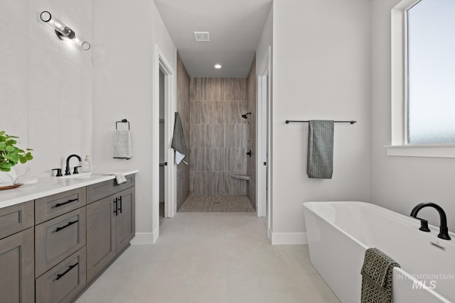 6920 N Spencer Way, Meridian, ID 83646 - full bathroom featuring vanity, a walk in shower, a soaking tub, and baseboards