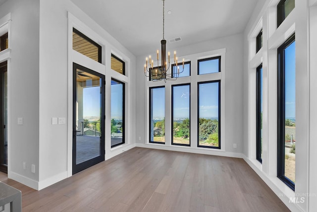 interior space with an inviting chandelier and hardwood / wood-style floors