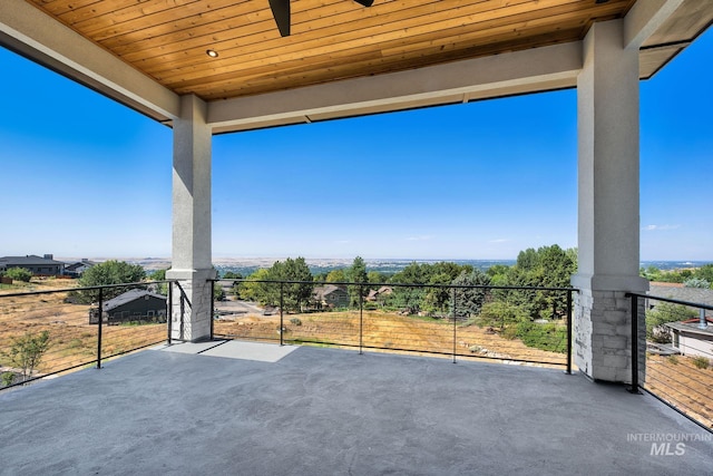 view of patio with ceiling fan and a balcony