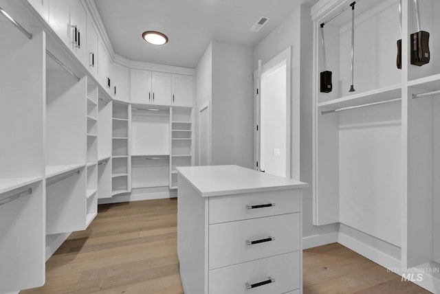 walk in closet with light wood-type flooring