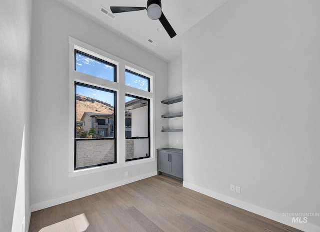 empty room with ceiling fan and light hardwood / wood-style floors