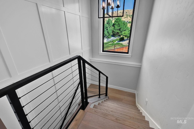 staircase featuring a chandelier and wood-type flooring