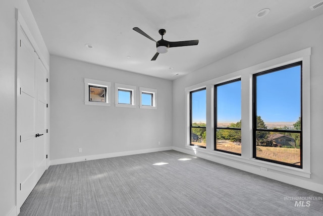 carpeted spare room with ceiling fan