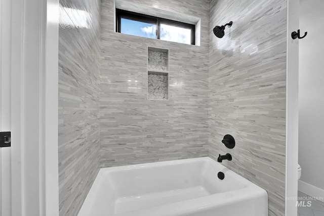 bathroom featuring tiled shower / bath