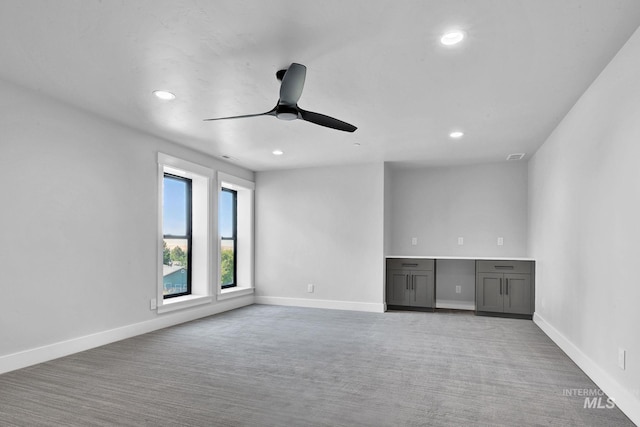 unfurnished room featuring ceiling fan and light carpet