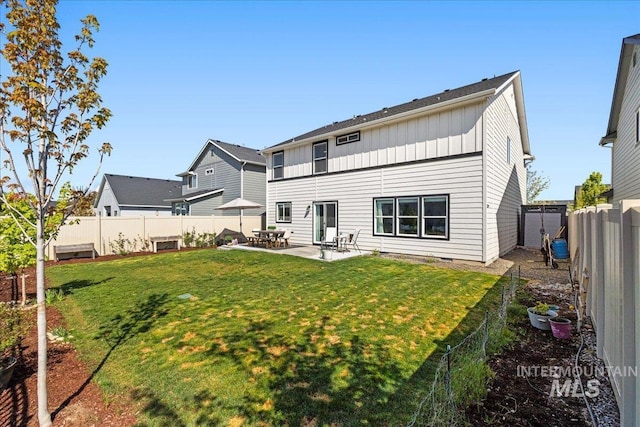 4447 W Everest St, Meridian, ID 83646 - rear view of property with a lawn, board and batten siding, a patio area, and a fenced backyard