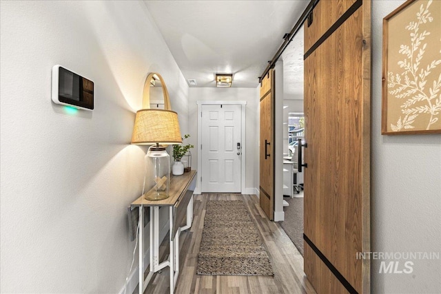 4447 W Everest St, Meridian, ID 83646 - hallway with baseboards, a barn door, and light wood finished floors