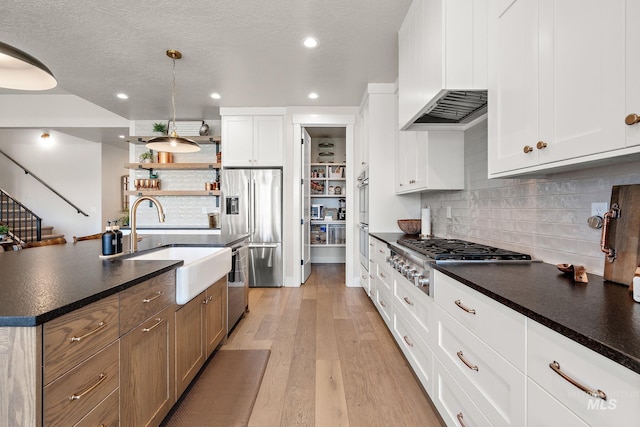 5209 W Strant Steet, Eagle, ID 83616 - kitchen with appliances with stainless steel finishes, dark countertops, light wood-style floors, tasteful backsplash, and recessed lighting