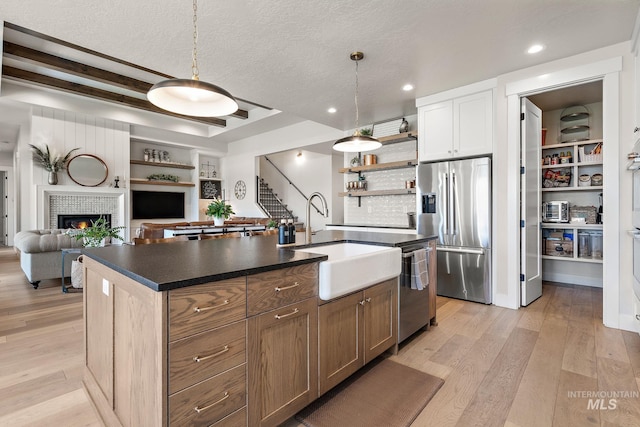 5209 W Strant Steet, Eagle, ID 83616 - kitchen with stainless steel appliances, dark countertops, open shelves, light wood-type flooring, and a textured ceiling