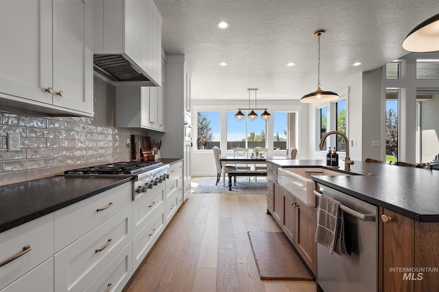 5209 W Strant Steet, Eagle, ID 83616 - kitchen featuring appliances with stainless steel finishes, dark countertops, plenty of natural light, recessed lighting, and wall chimney range hood