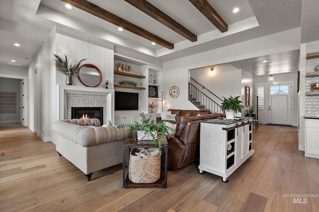 5209 W Strant Steet, Eagle, ID 83616 - living room featuring light wood-style flooring, stairway, built in shelves, a fireplace, and beam ceiling