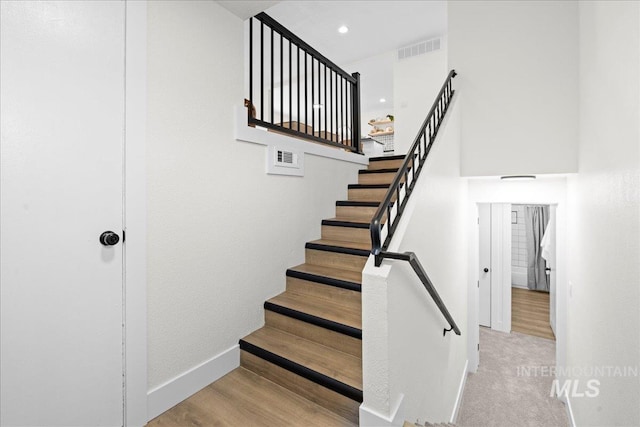 staircase with hardwood / wood-style floors