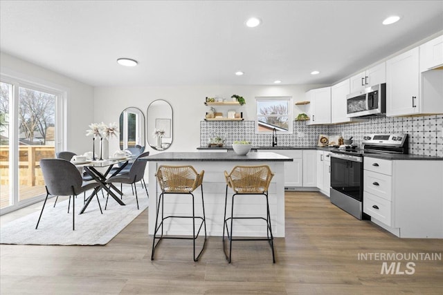 kitchen with white cabinets, plenty of natural light, and stainless steel appliances