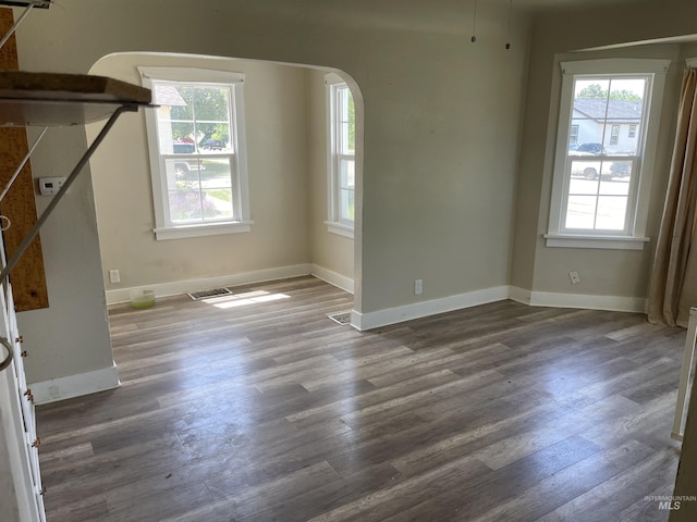 512 19th Ave S, Nampa, ID 83651 - unfurnished living room featuring arched walkways, dark wood-style floors, and baseboards
