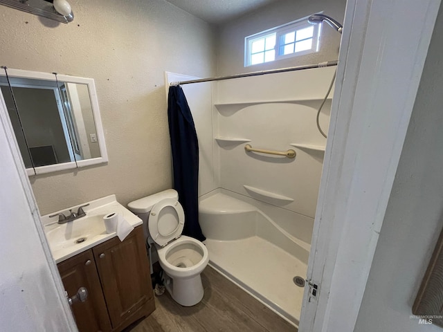 512 19th Ave S, Nampa, ID 83651 - full bathroom with vanity, a shower with shower curtain, toilet, and wood finished floors