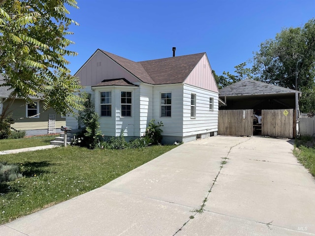 512 19th Ave S, Nampa, ID 83651 - view of front of property with board and batten siding, a detached carport, a front lawn, a shingled roof, and concrete driveway