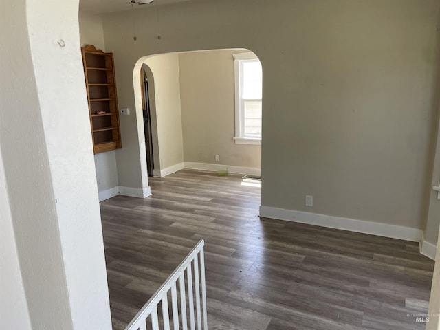 512 19th Ave S, Nampa, ID 83651 - spare room featuring arched walkways, dark wood-style flooring, and baseboards