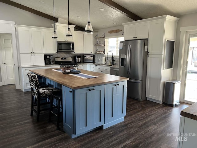 kitchen with butcher block countertops, a textured ceiling, open shelves, and stainless steel appliances