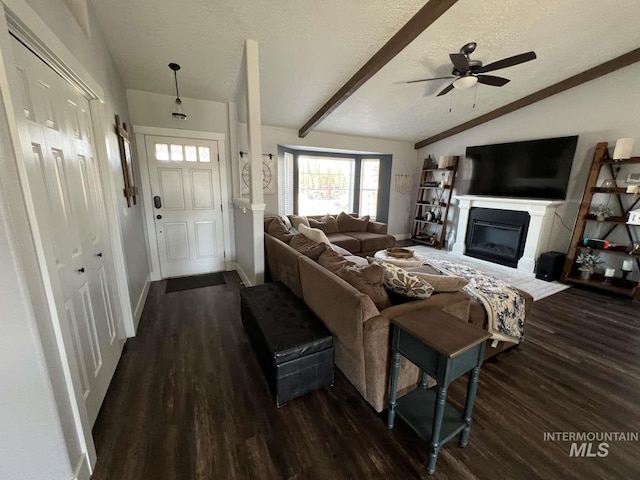 living area featuring lofted ceiling with beams, baseboards, dark wood-style floors, and a textured ceiling