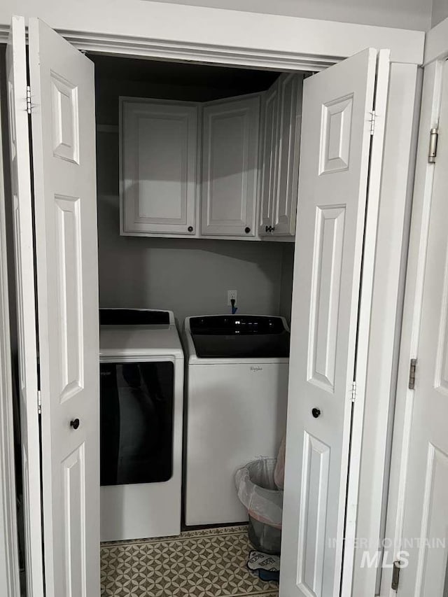laundry room featuring separate washer and dryer and cabinet space