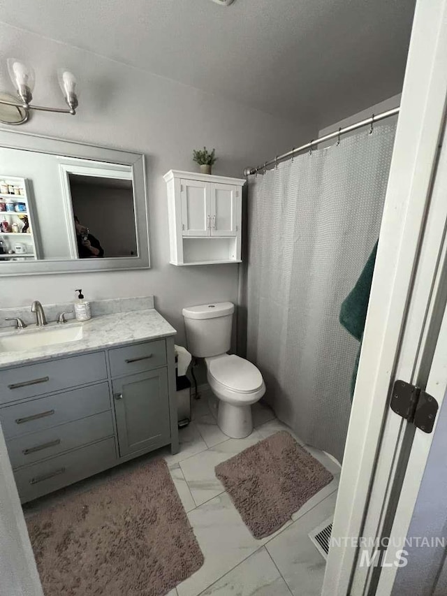 full bath featuring visible vents, marble finish floor, vanity, and toilet
