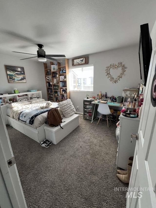 bedroom featuring a ceiling fan, carpet flooring, and a textured ceiling