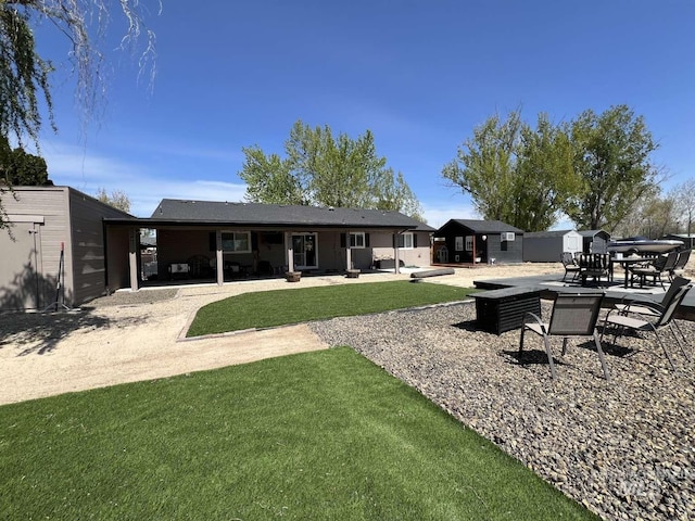 back of house with a yard and a patio