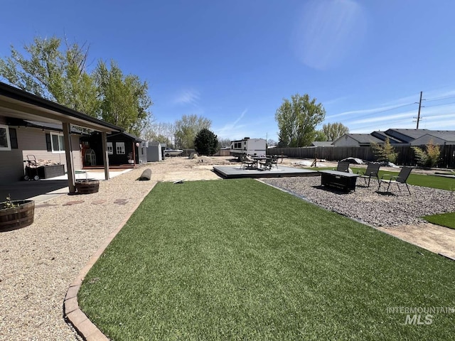 view of yard with a fenced backyard, a patio area, and an outdoor fire pit