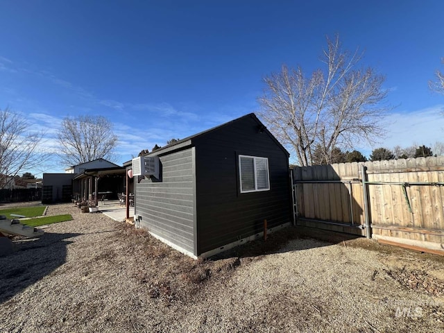 view of outbuilding featuring fence and an outbuilding