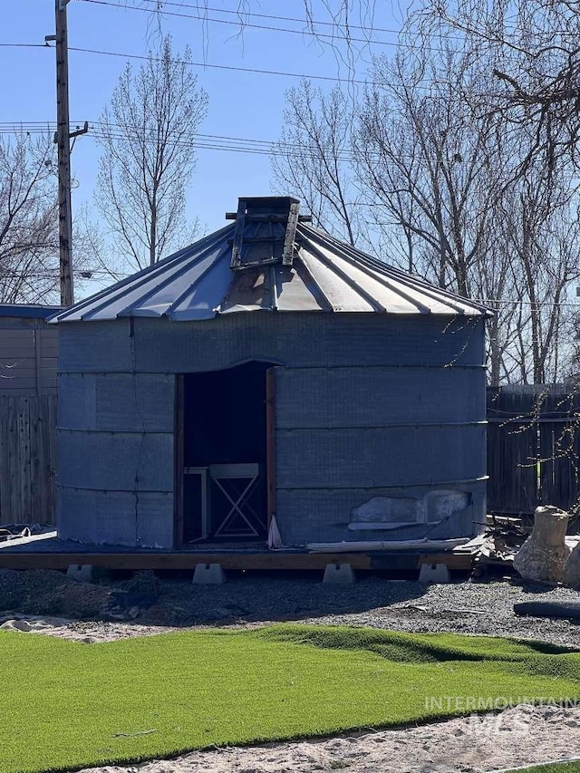 view of outbuilding featuring fence and an outbuilding